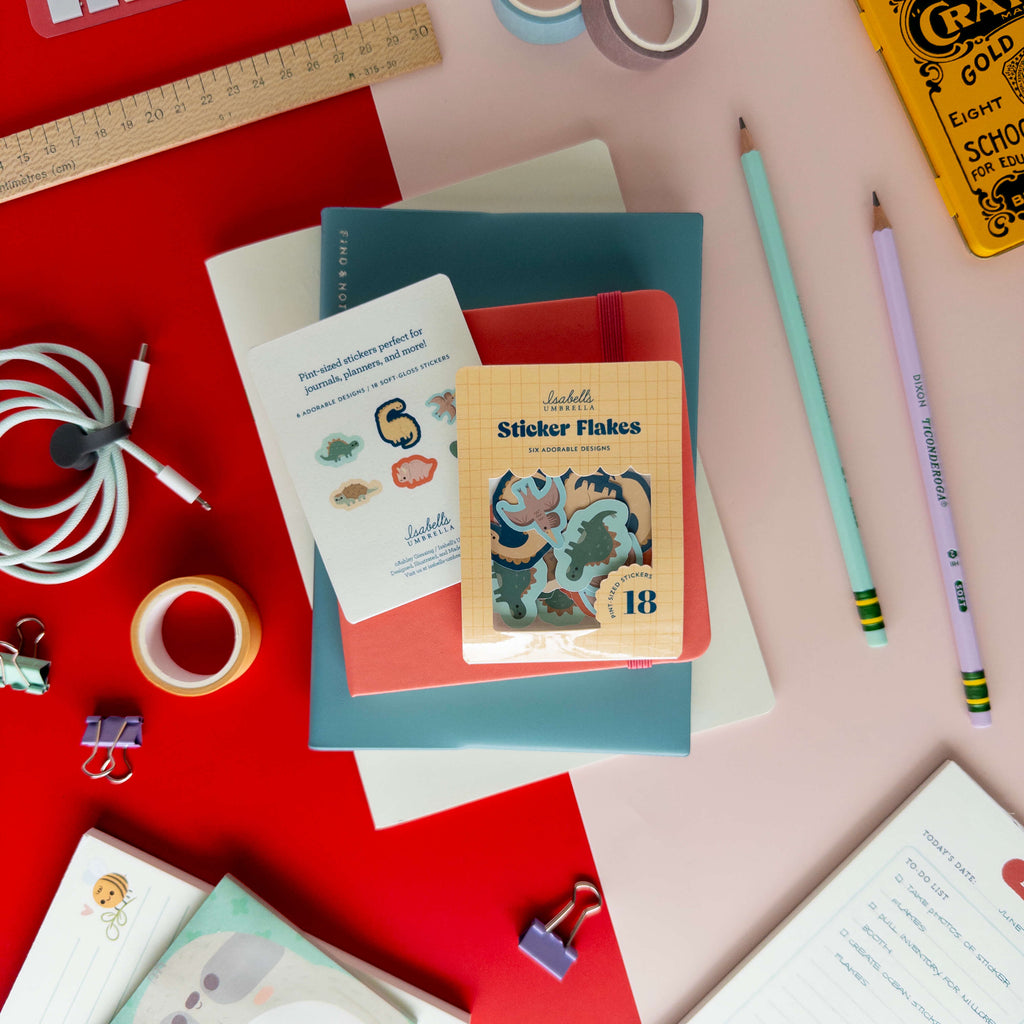Cute dinosaur sticker flakes displayed with the packaging, individual stickers, and colorful stationery.