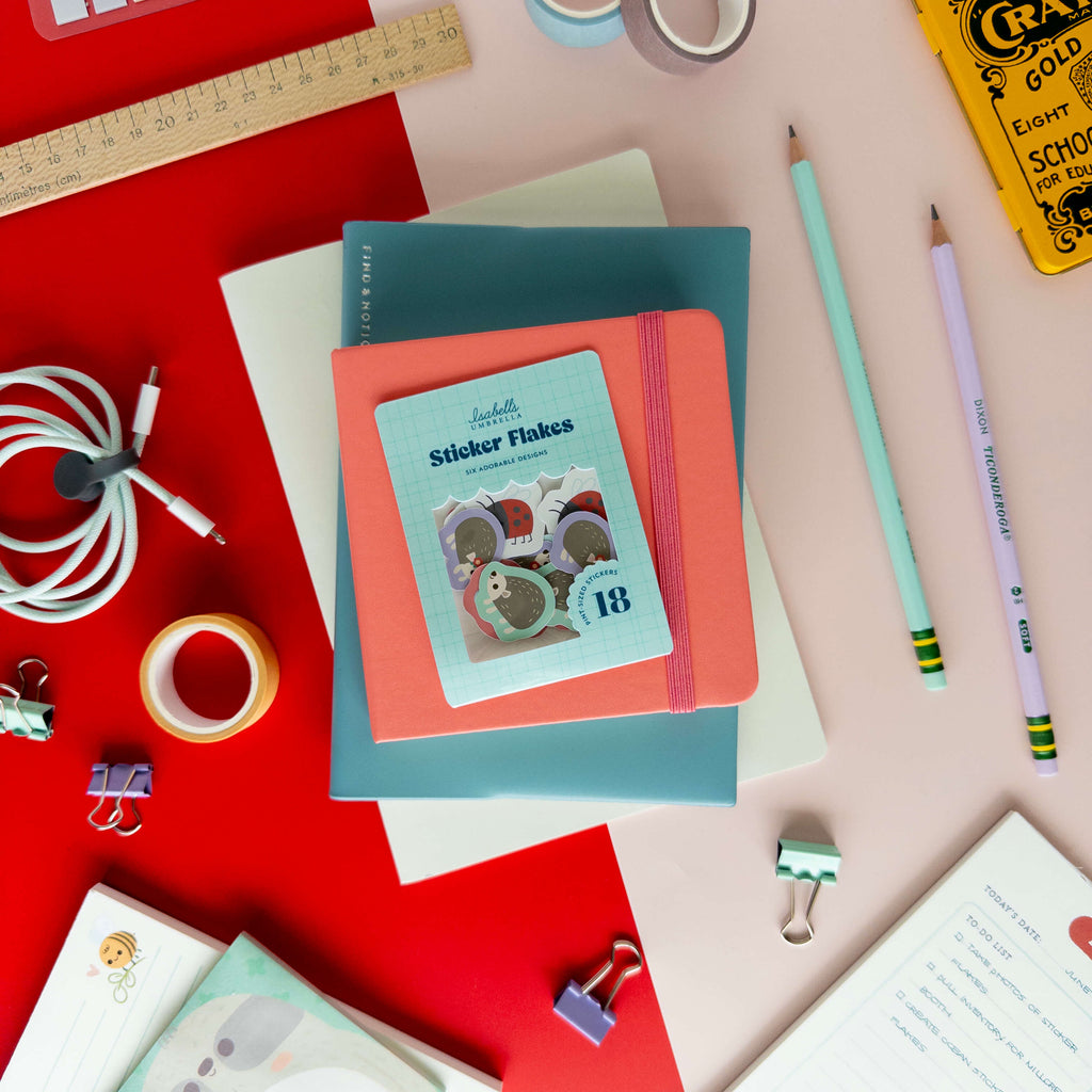 Pack of cute hedgehog sticker flakes displayed on colorful notebooks and stationery.