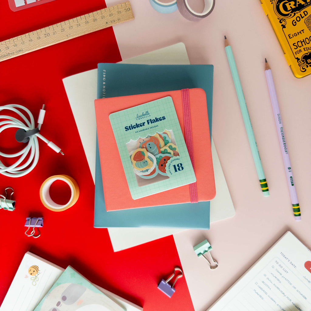 Pack of cute roly poly sticker flakes displayed on colorful notebooks and stationery.