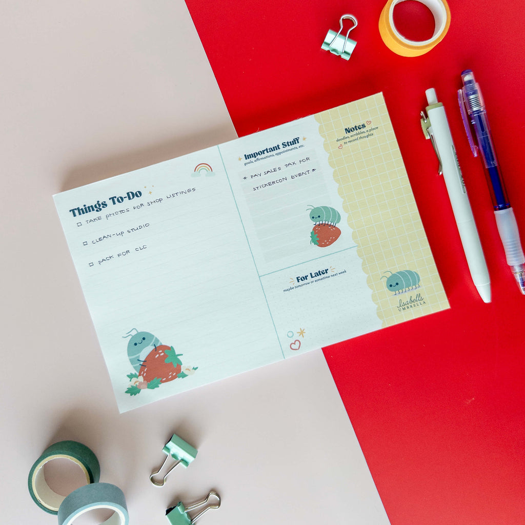 Roly poly planner pad with a to-do list and notes section displayed with colorful stationery supplies.