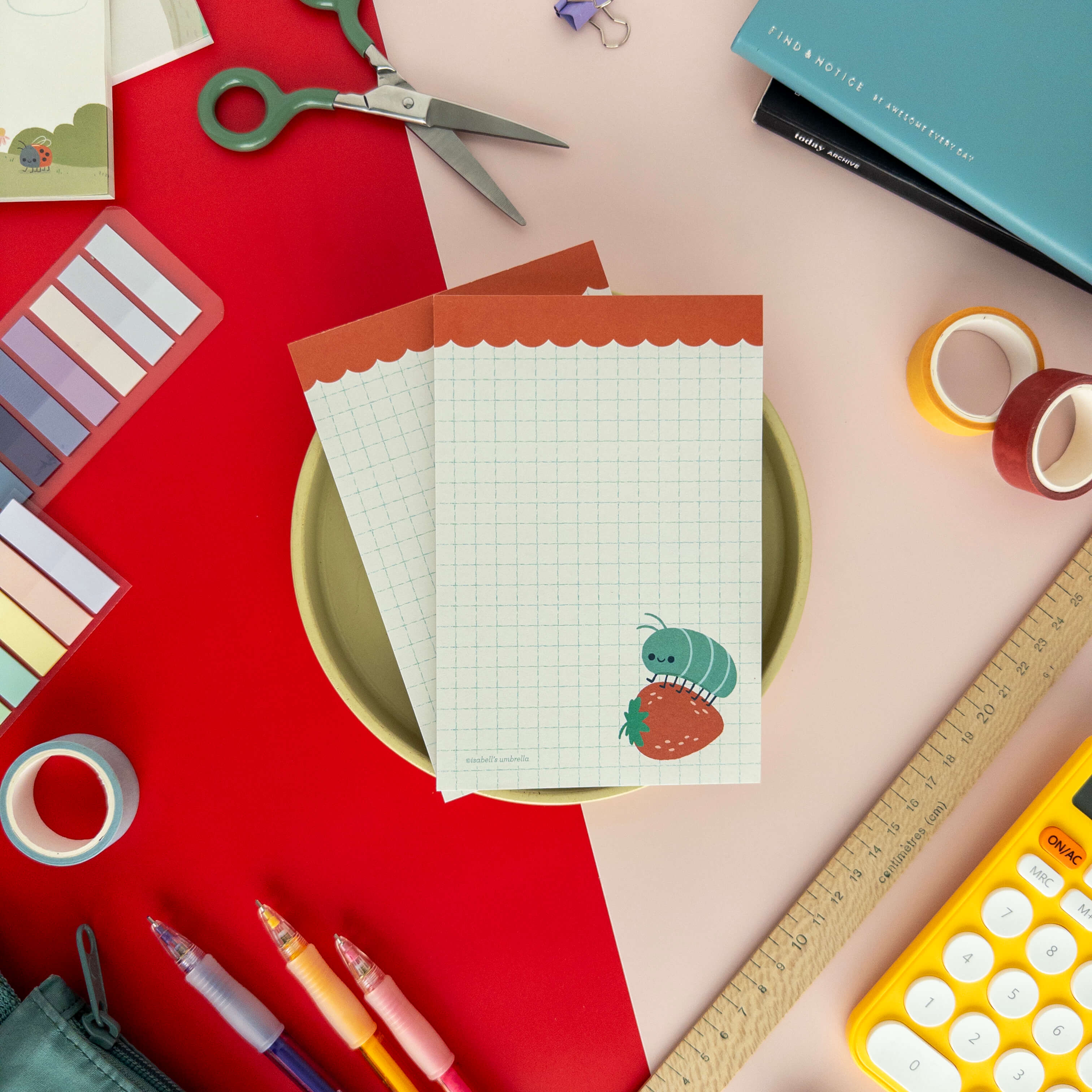 Hedgehog illustrated notepad displayed on a red and cream background with colorful pens.