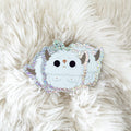 A cute glittery yeti vinyl sticker sitting on a faux sheep skin blanket