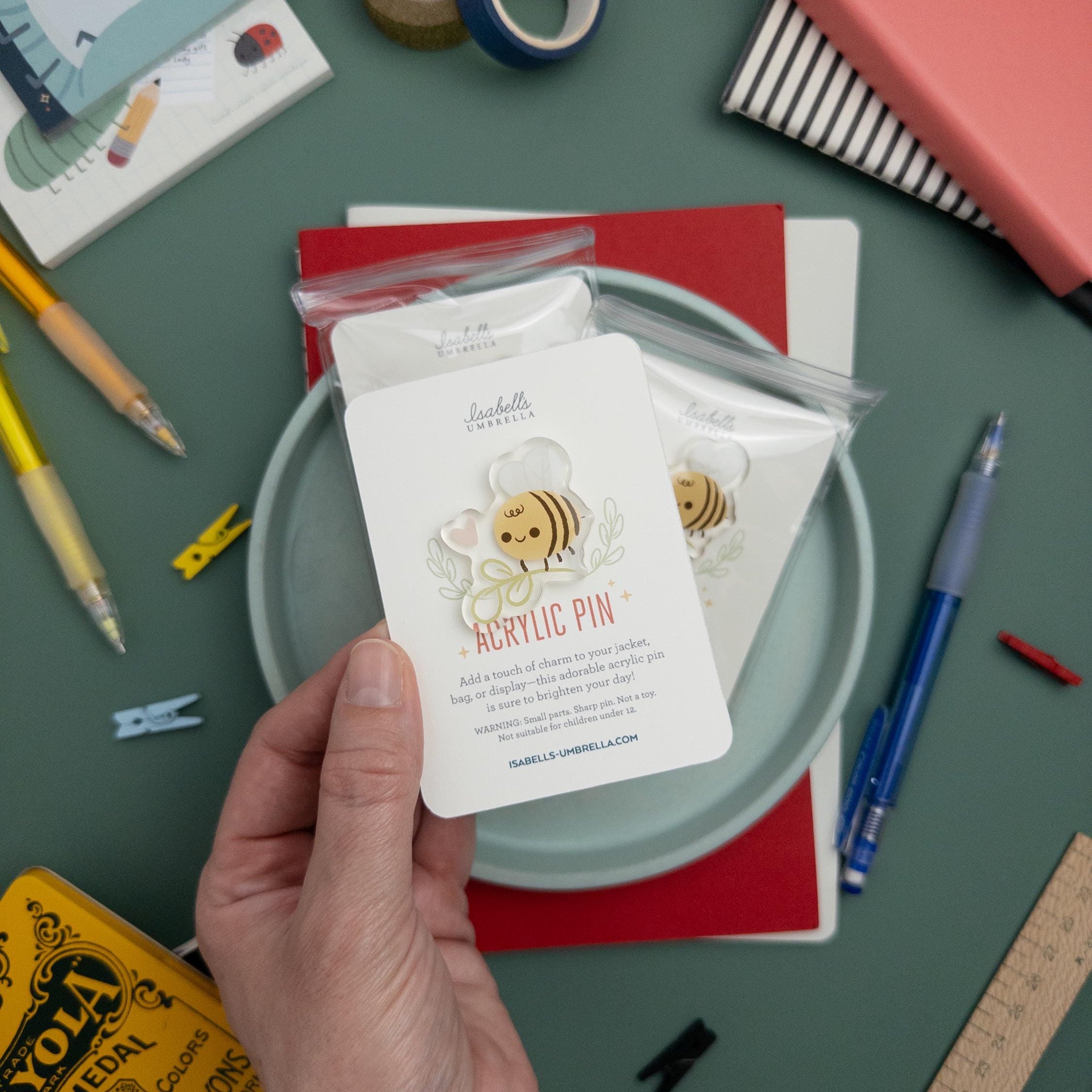 Hand holding a cute bee with flower acrylic pin featuring glossy epoxy finish, kawaii cottagecore brooch perfect for jackets, totes, and gifts for bee lovers