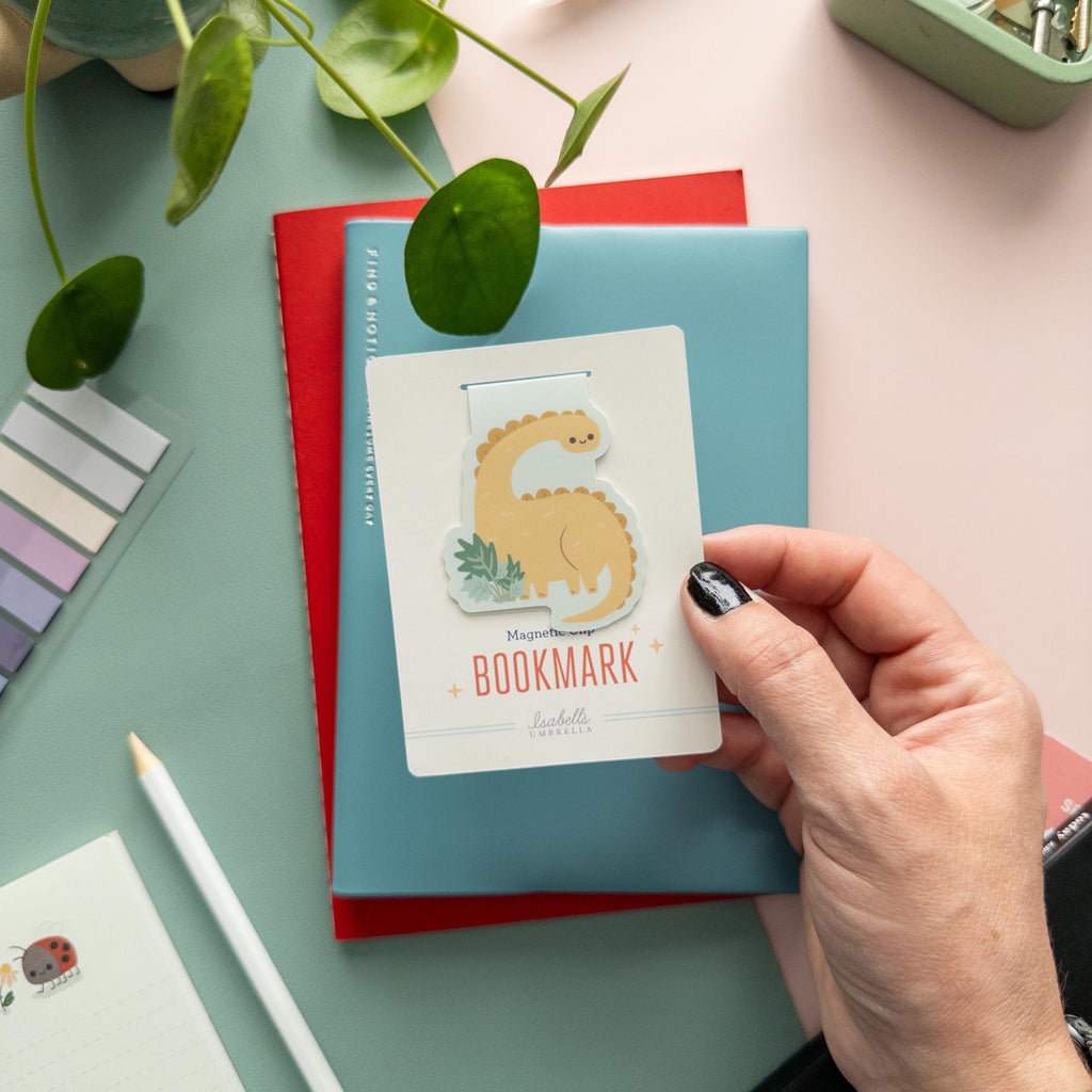 Brontosaurus magnetic bookmark displayed on branded backer card, matte laminated finish, cute dino gift for readers.