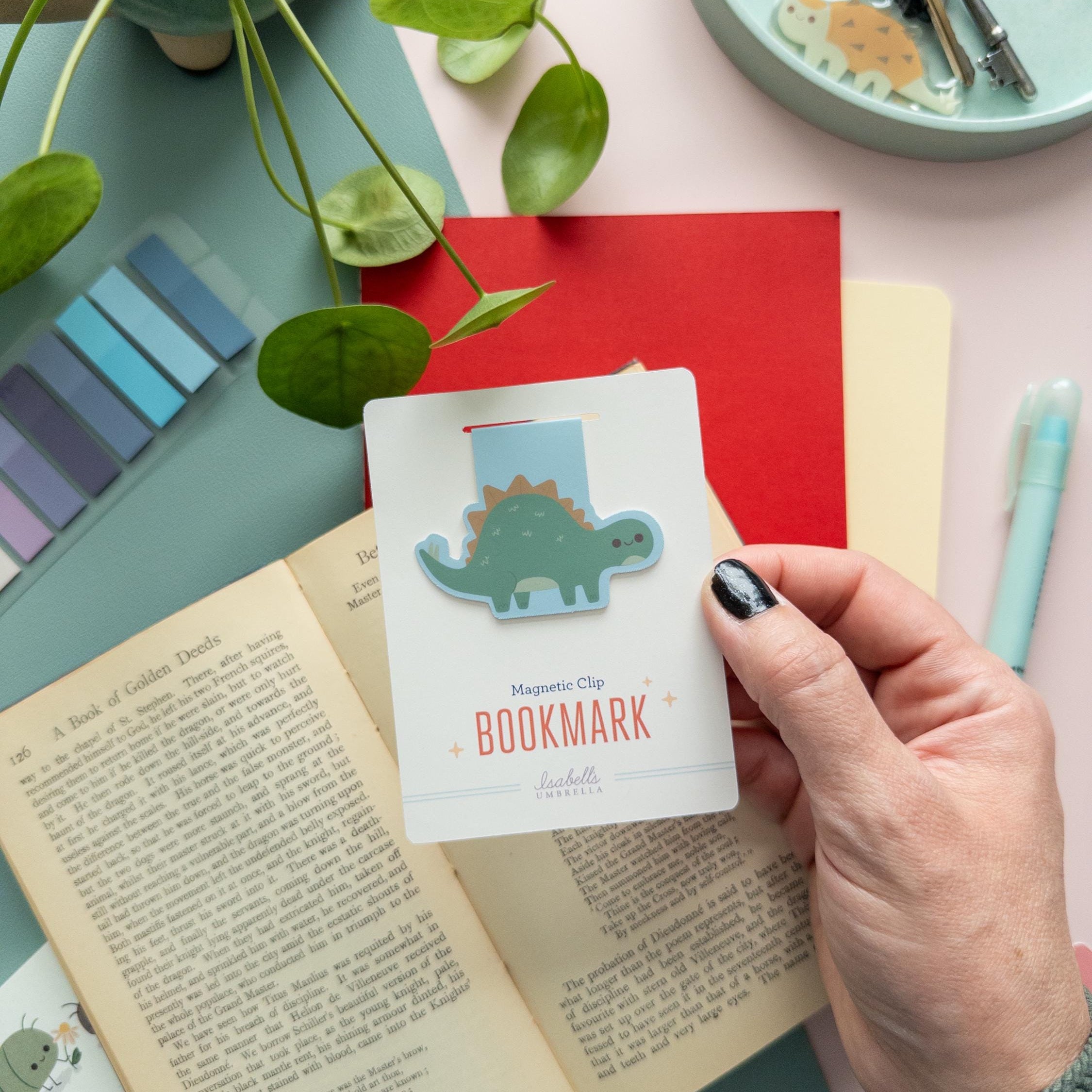 Stegosaurus magnetic bookmark displayed on branded backer card, matte laminated finish, fun dino gift for readers.