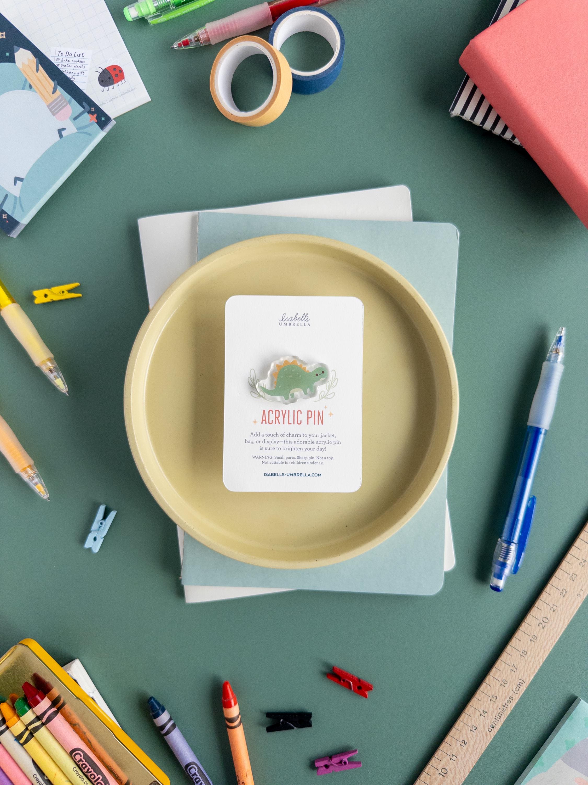 Cute pastel green Stegosaurus acrylic pin with glossy epoxy finish, kawaii dinosaur enamel-style pin for dino lovers and collectors.