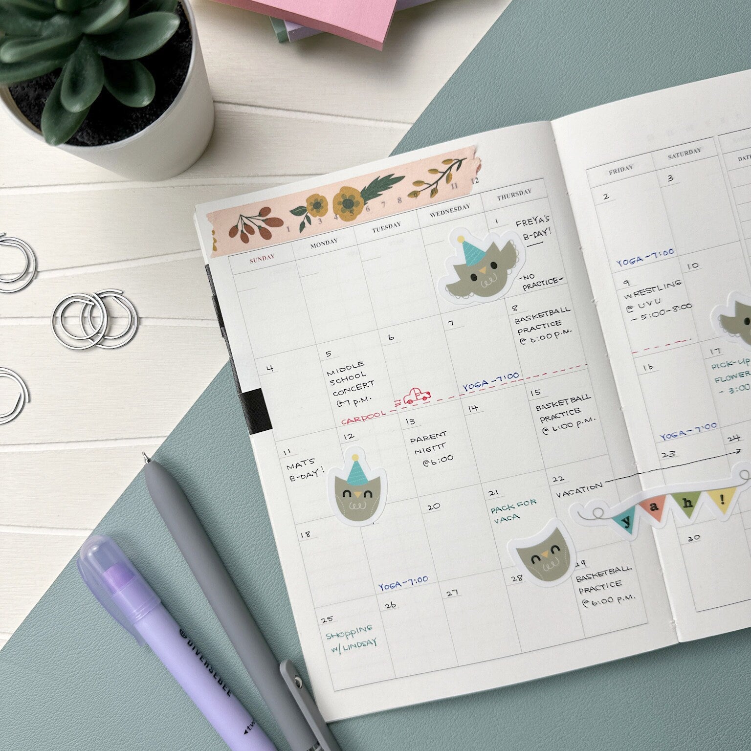 Calendar adorned with adorable owl stickers wearing party hats and a banner that spells out "yah!".