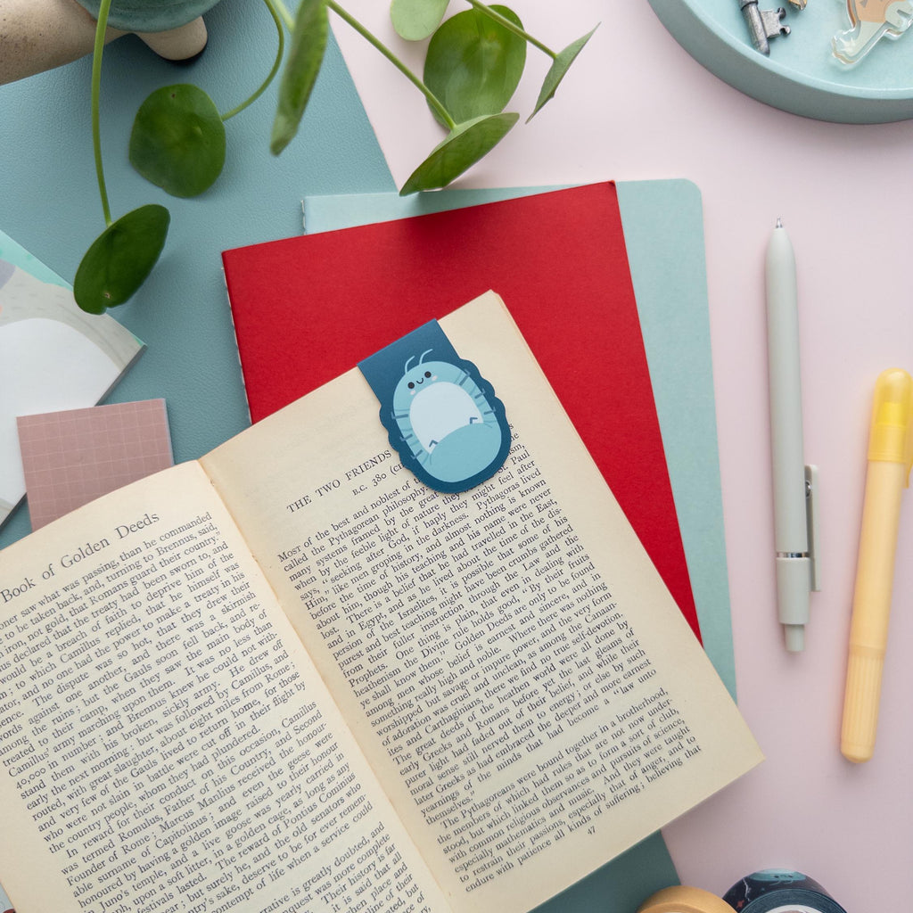 Roly Poly bug magnetic bookmark clipped to a book page, cute kawaii reading accessory for students and nature lovers.