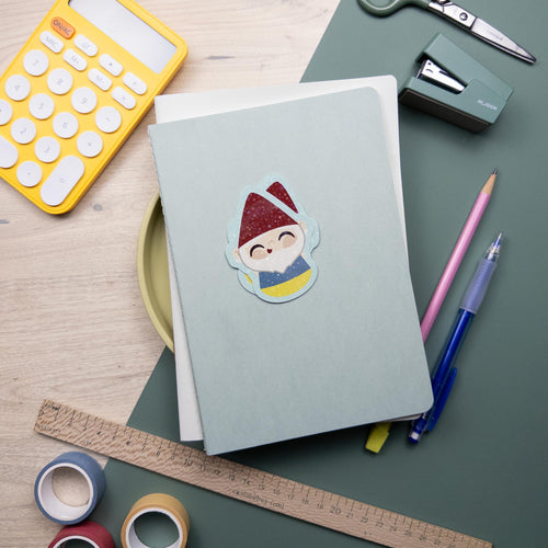 A cute glitter garden gnome vinyl sticker, waterproof and durable kawaii decal for laptops, water bottles, and journals, cottagecore design.