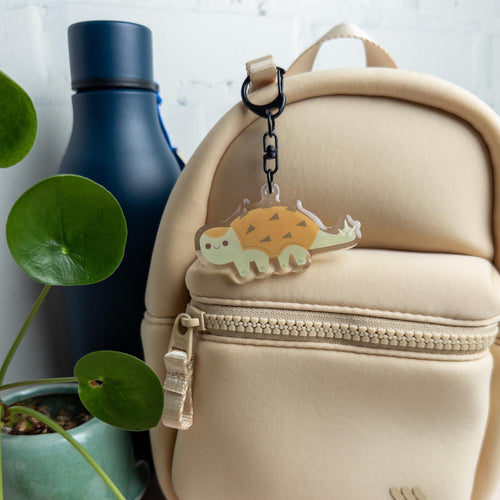 Cute pastel Ankylosaurus acrylic keychain with glossy epoxy finish, kawaii dinosaur bag charm for keys, backpacks, and gifts.