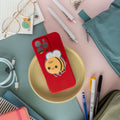 Red phone case with a magnetic phone grip of a bee on a desk with stationery items