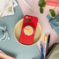 Red phone case with a magnetic phone grip of a pufferfish on a table with stationery. 