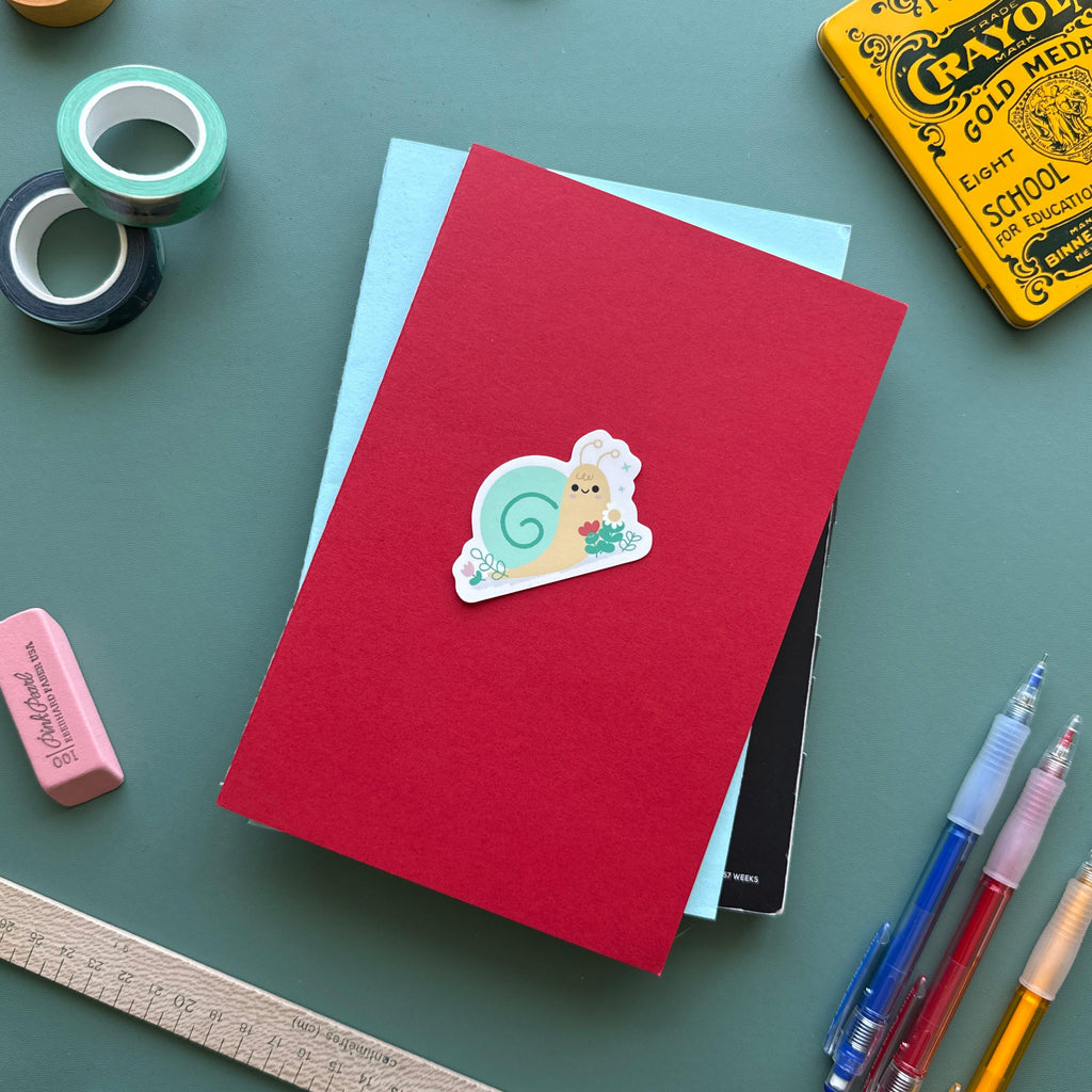 Cute snail with flowers vinyl sticker, waterproof matte decal featuring a snail surrounded by cheerful blooms, perfect for laptops, water bottles, and journals