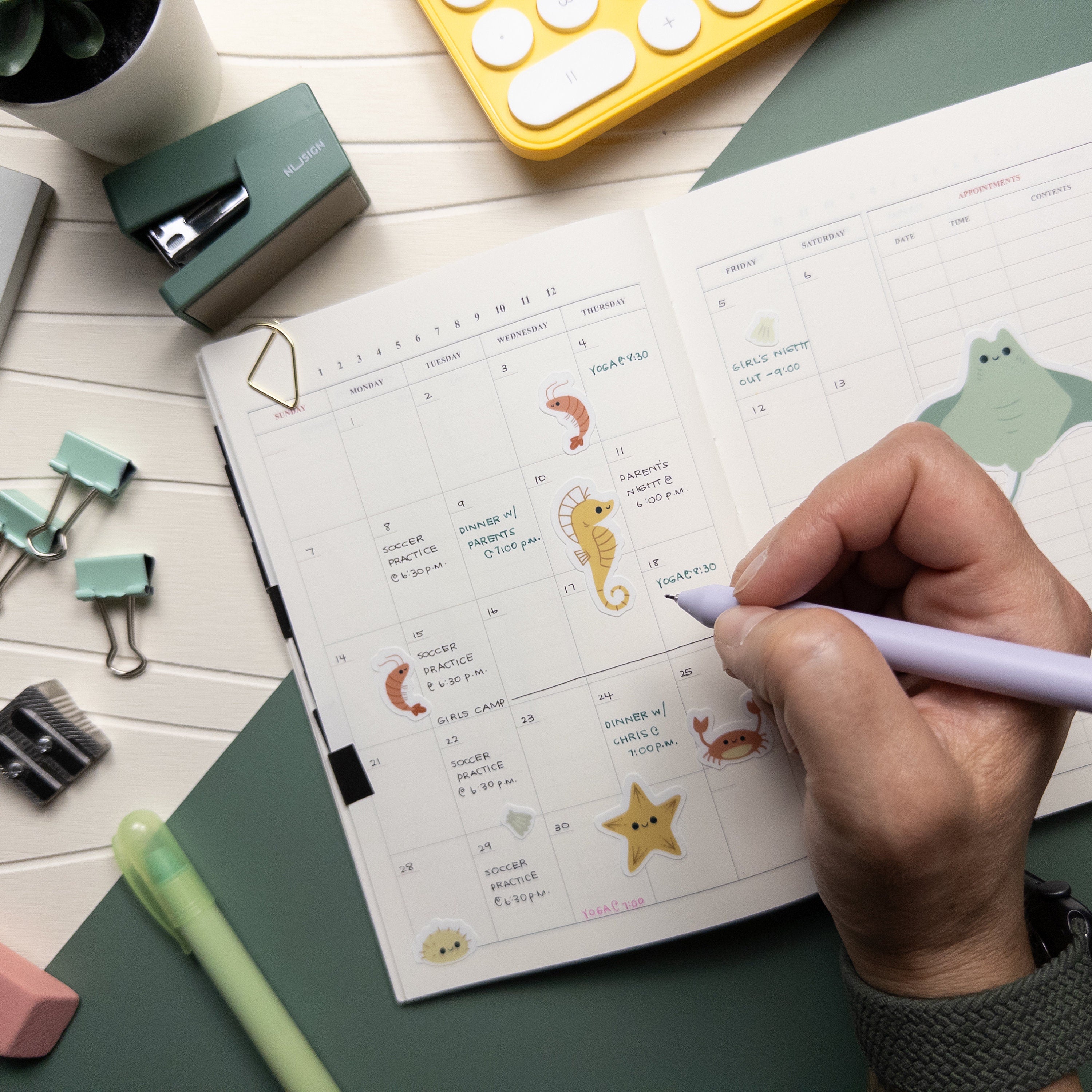 Hand writing on a calendar that uses stickers to illustrate events and also provide decoration for the page.