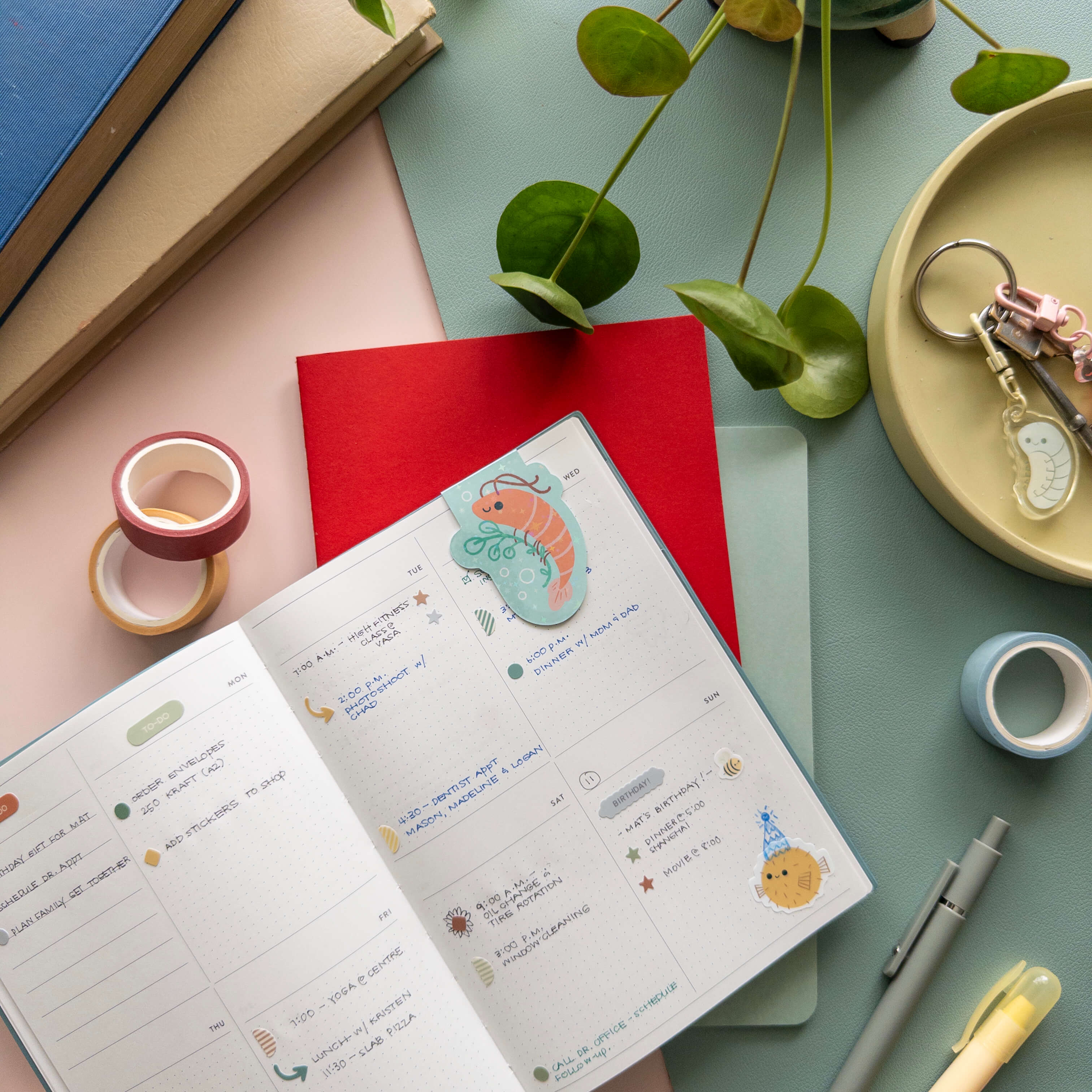 Open notebook with magnetic shrimp bookmark  on a desk with stationery items